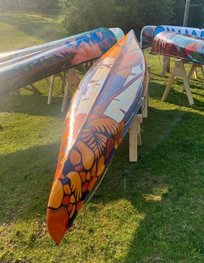 Painted canoe displayed in park viewed from the right side