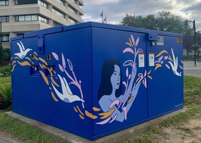 Deep Blue painted power box with woman painted on it letting plants, birds and shapes flow through her arms.