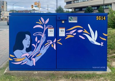 Deep Blue painted power box with woman painted on it letting plants, birds and shapes flow through her arms.