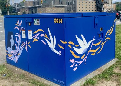 Deep Blue painted power box with woman painted on it letting plants, birds and shapes flow through her arms.