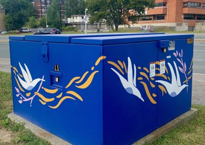 Deep Blue painted power box with white painted birds on it carrying pink branches.