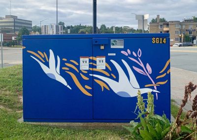 Deep Blue painted power box with white painted birds on it carrying pink branches.